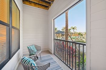 A balcony with a chair and a pillow.
